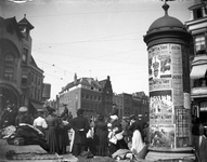 72582 Gezicht op de noordoosthoek van de Neude te Utrecht tijdens de warenmarkt; rechts een reclamezuil (Litfasssäule) ...